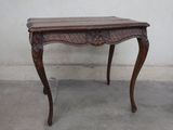 a small table with a wooden top on a cement floor