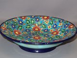 a blue bowl with a colorful floral design on it