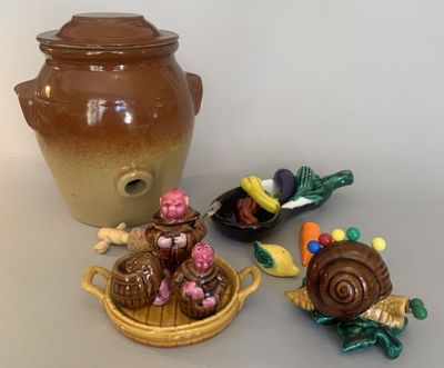 a brown vase, a bowl, and some small figurines on a table