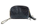 a black leather bag with a chain strap and tassels