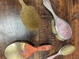 trois pinceaux et un pinceau posé sur une table en bois