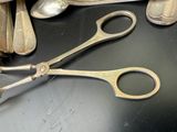 une paire de ciseaux posée sur une table à côté de cuillères et de cuillères