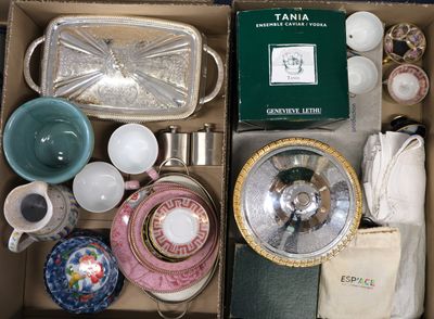 une boîte remplie d'objets divers, notamment de vaisselle, de tasses, d'assiettes et de bols