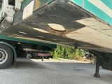 un camion vert et blanc garé dans la rue