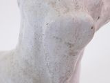 a close up of a white dog statue on a white surface