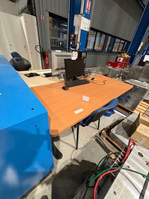 a desk with a computer on it in a warehouse