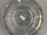 a clear glass bowl with a gold rim on a white table