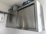 une armoire en acier inoxydable dans un coin de la salle de bains