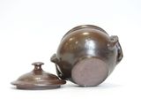 a small brown teapot next to a small brown tea pot