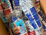 une boîte remplie de ficelle bleue et blanche emballée dans du plastique