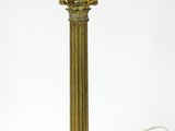 an antique brass table lamp with a white cord attached to it