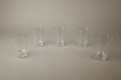 quatre vases en verre transparent sont alignés sur une surface blanche