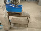 une boîte bleue contenant des outils, posée sur une table dans un garage