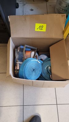 une boîte en carton posée par terre et remplie d'objets divers