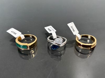 trois anneaux de couleurs différentes posés sur une table, accompagnés d'étiquettes