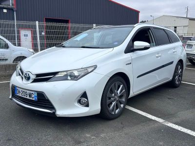 la Toyota Auris blanche garée sur un parking à côté d'un immeuble