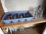 a blue tray with silverware in it on a wooden shelf