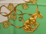 écharpe verte et dorée ornée d'un motif représentant un cheval