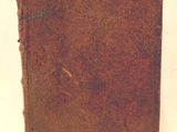 un livre marron sur lequel sont inscrits des mots, posé sur une table