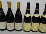 six bottles of wine are lined up in a row on a table