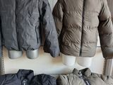 two jackets and a bag sitting on a table in front of a radiator