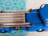 un petit camion bleu en plastique posé sur une table