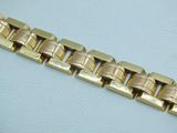 a close up of a gold bracelet on a white surface