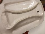 a person holding a white plate with a curved design on it