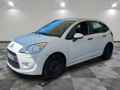the small white car is parked in a room with a checkered floor