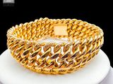 gold plated bracelet on a white plate with a black background