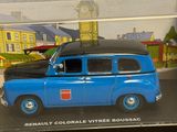 a blue toy car in a clear box with a clock tower in the background