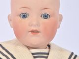a doll that is wearing a sailor suit and a hat