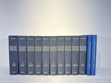 four books are lined up in a row on a white surface