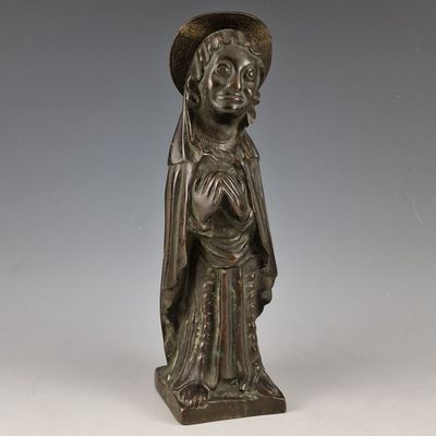 une statue en bronze d'une femme avec un chapeau sur la tête