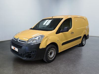La camionnette jaune est garée dans une grande pièce au sol noir.