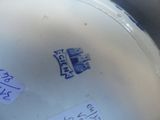 a close up of a white vase with a blue label on it