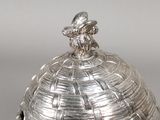 a silver plate with a bird on top of it