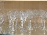 des bouteilles et des verres posés sur une étagère en verre dans un magasin