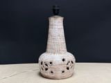 a white vase with holes on it sitting on a table