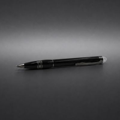 un stylo noir posé sur une table, devant un fond noir