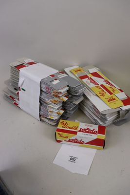 une pile de paquets de cigarettes posée sur une table à côté d'un paquet de cigarettes