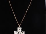 a necklace with a cross on a black mannequin