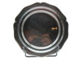 a silver plate on a stand with a reflection of a person in it