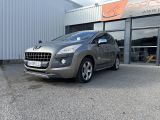 La voiture grise est garée à l'extérieur du bâtiment, devant celui-ci.