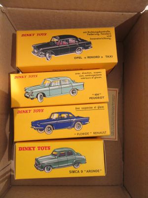 trois boîtes de petites voitures sont empilées les unes sur les autres dans un carton