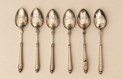 six cuillères sont alignées sur une surface blanche