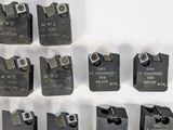 several pieces of metal are arranged in rows on a white surface