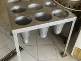 stainless steel muffin pans on a table in a commercial kitchen
