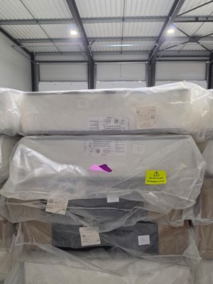 many mattresses stacked on top of each other in a warehouse