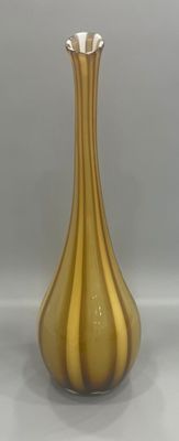 a gold vase sitting on a table with a white background
